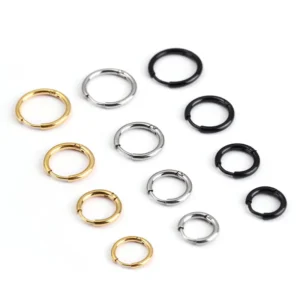 Douze créoles fines disposées en éventail sur fond blanc, en trois coloris (doré, acier, noir) et du plus petit au plus grand diamètre