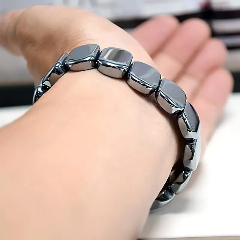 Bracelet d'hématite porté au poignet, perles plates polies