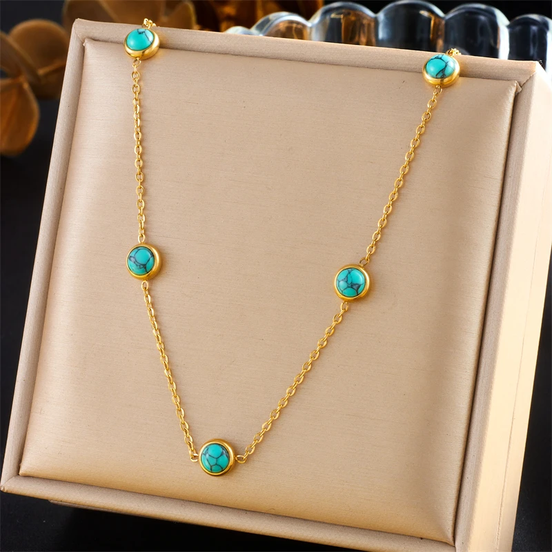 Le collier seul présenté à plat dans son écrin : chaîne forçat fine et cinq cabochons turquoise sertis clos