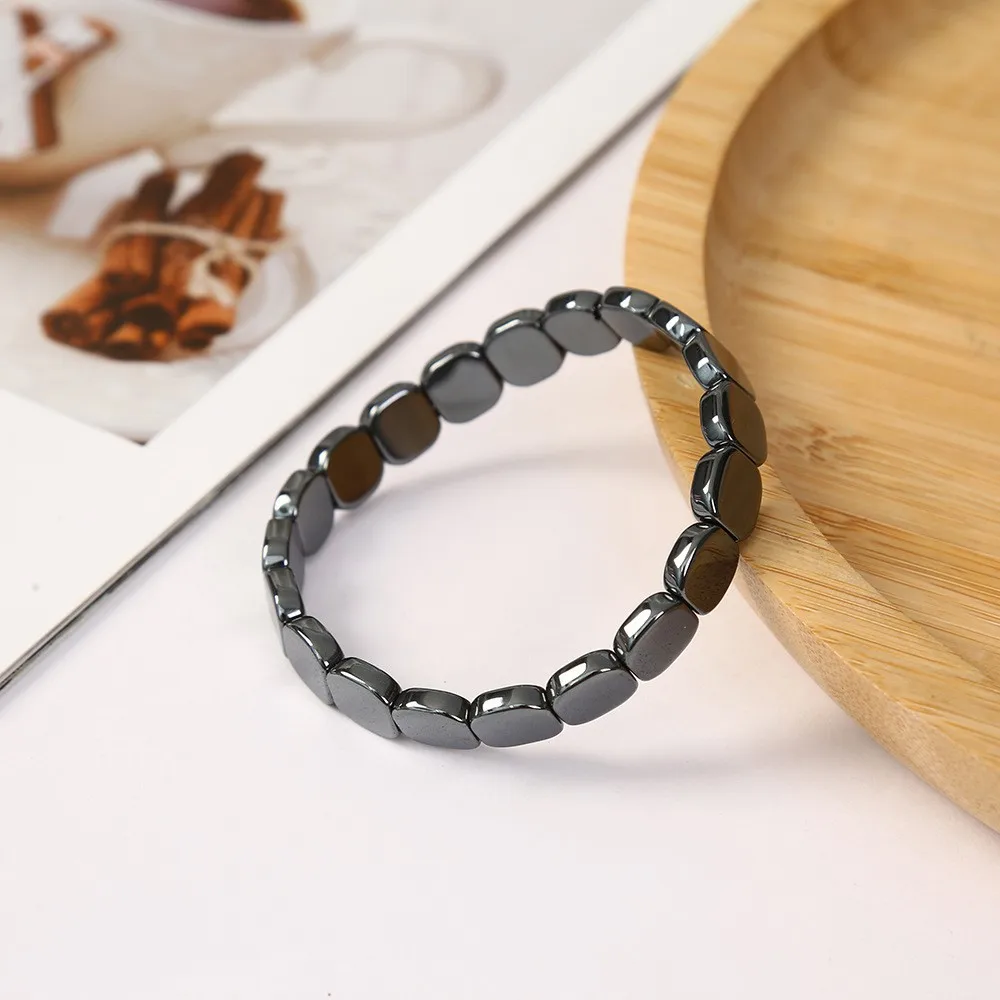 Bracelet d'hématite présenté sur un plateau en bois clair